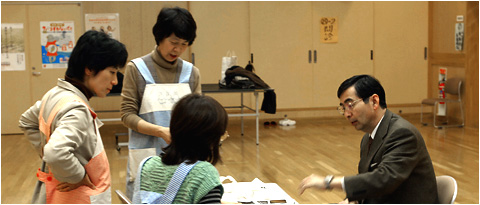 今井潤先生（右）やスタッフと打ち合わせをする浅沼さん（左から2人目）